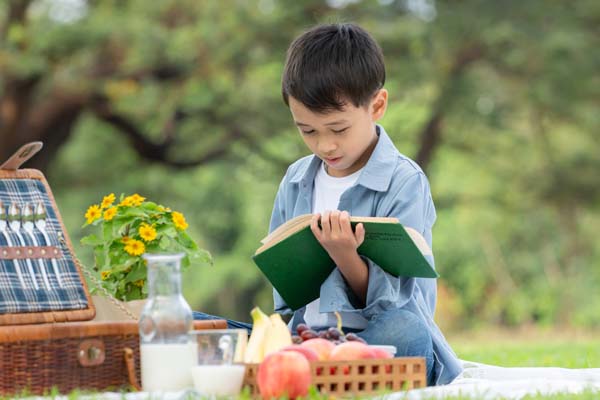 child reading book outside